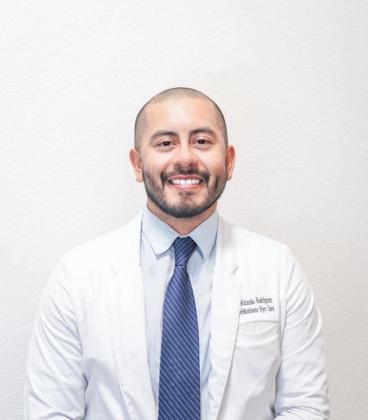 Dr. Ricardo Rodriguez of Eyemotivate Eye Care and Eyewear standing his white coat and tie