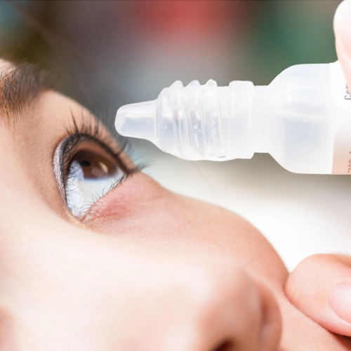 Close up of a woman's eye as she puts an eye drop in it